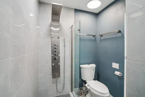 a bathroom with a toilet and a shower