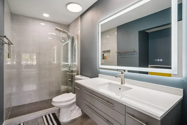 a bathroom with a sink a toilet and shower