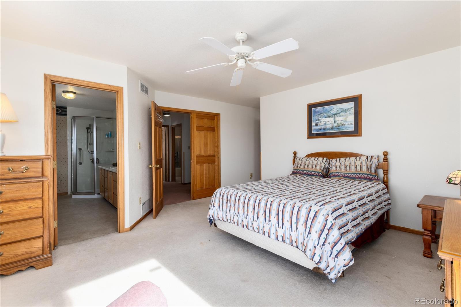 10650 Yellowstone Road Longmont, CO 80504 - Photo 22 of 43 a bedroom with a bed and a chandelier