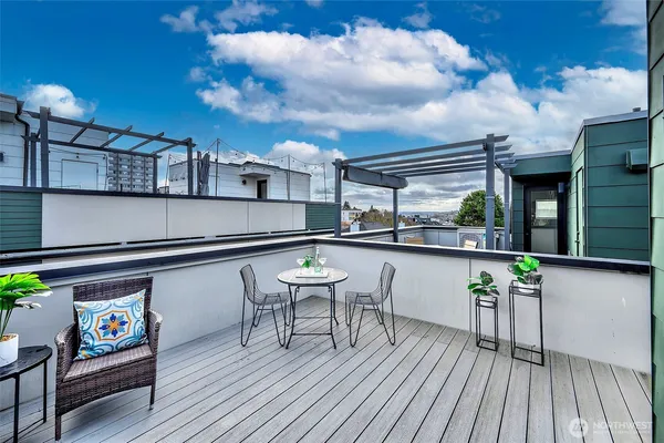 a roof deck view with table and chairs barbeque with wooden floor