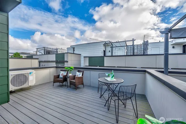 a view of a roof deck with table and chairs