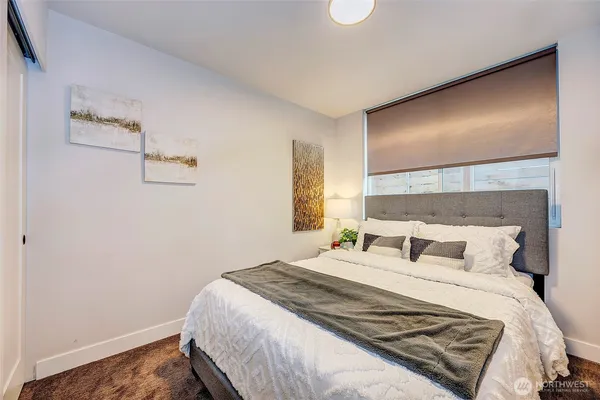 a bedroom with a bed and painting on the wall