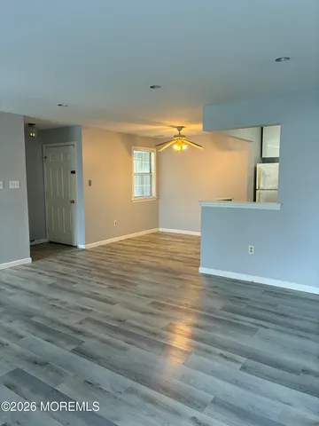 a view of a room with wooden floor and a window