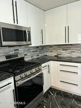 a kitchen with stainless steel appliances a stove and a microwave