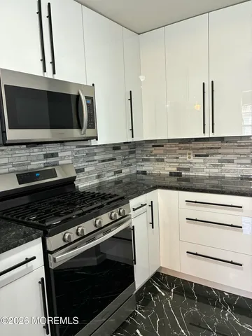 a kitchen with stainless steel appliances a stove and a microwave