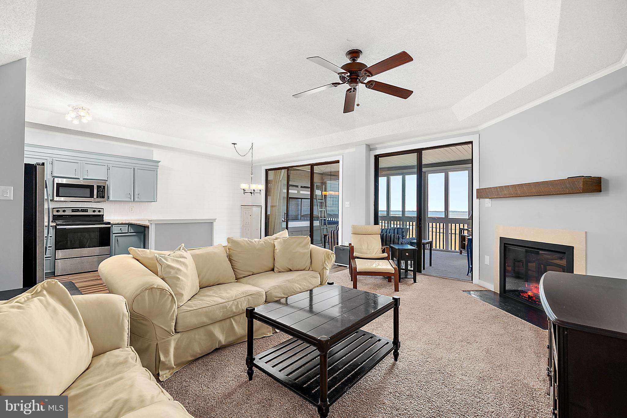 119 Old Landing Road, Unit 302B Ocean City, MD 21842 - Photo 19 of 46 a living room with furniture a fireplace and a flat screen tv