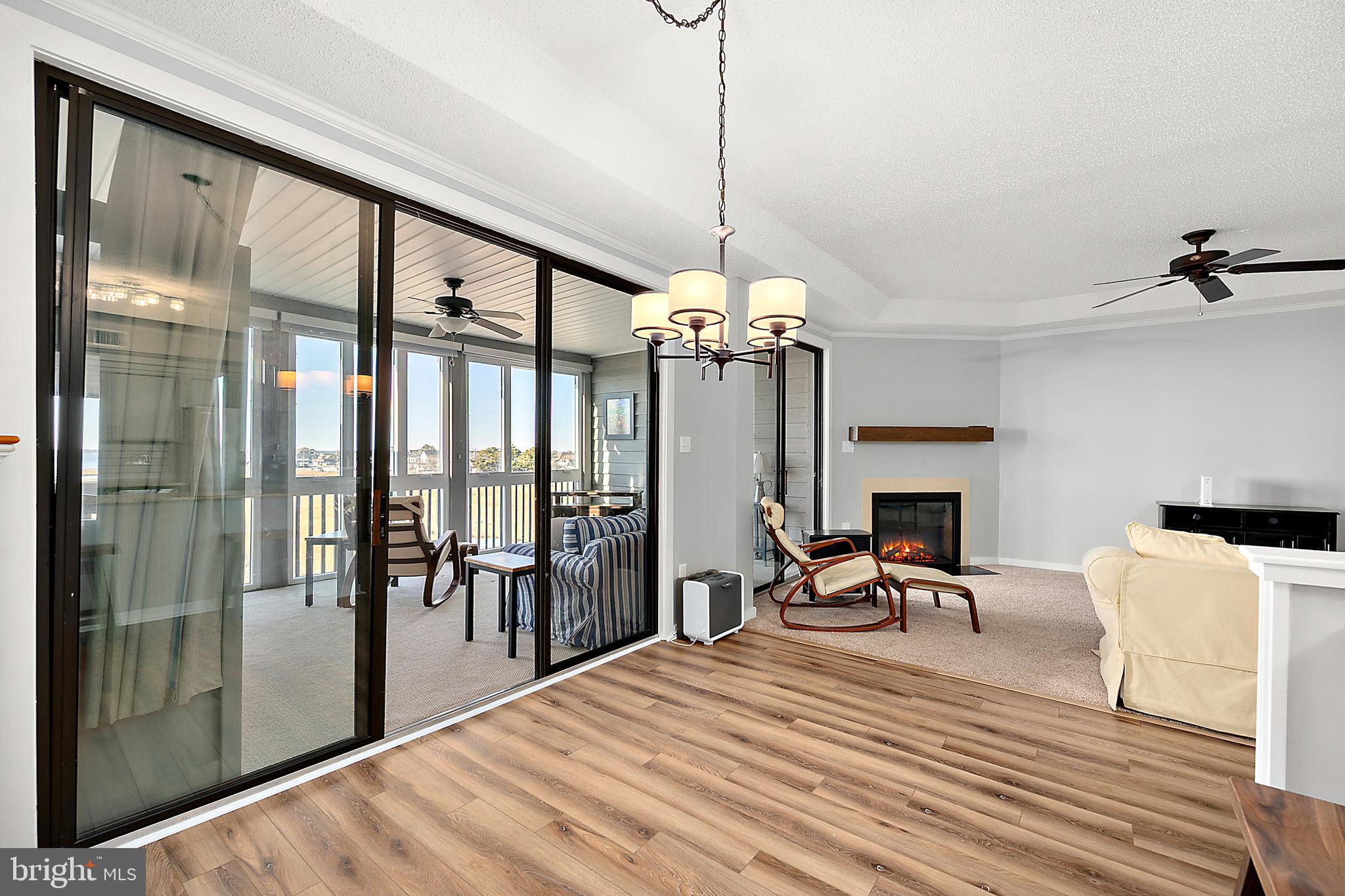 119 Old Landing Road, Unit 302B Ocean City, MD 21842 - Photo 21 of 46 a view of a dining room and livingroom with furniture wooden floor a chandelier