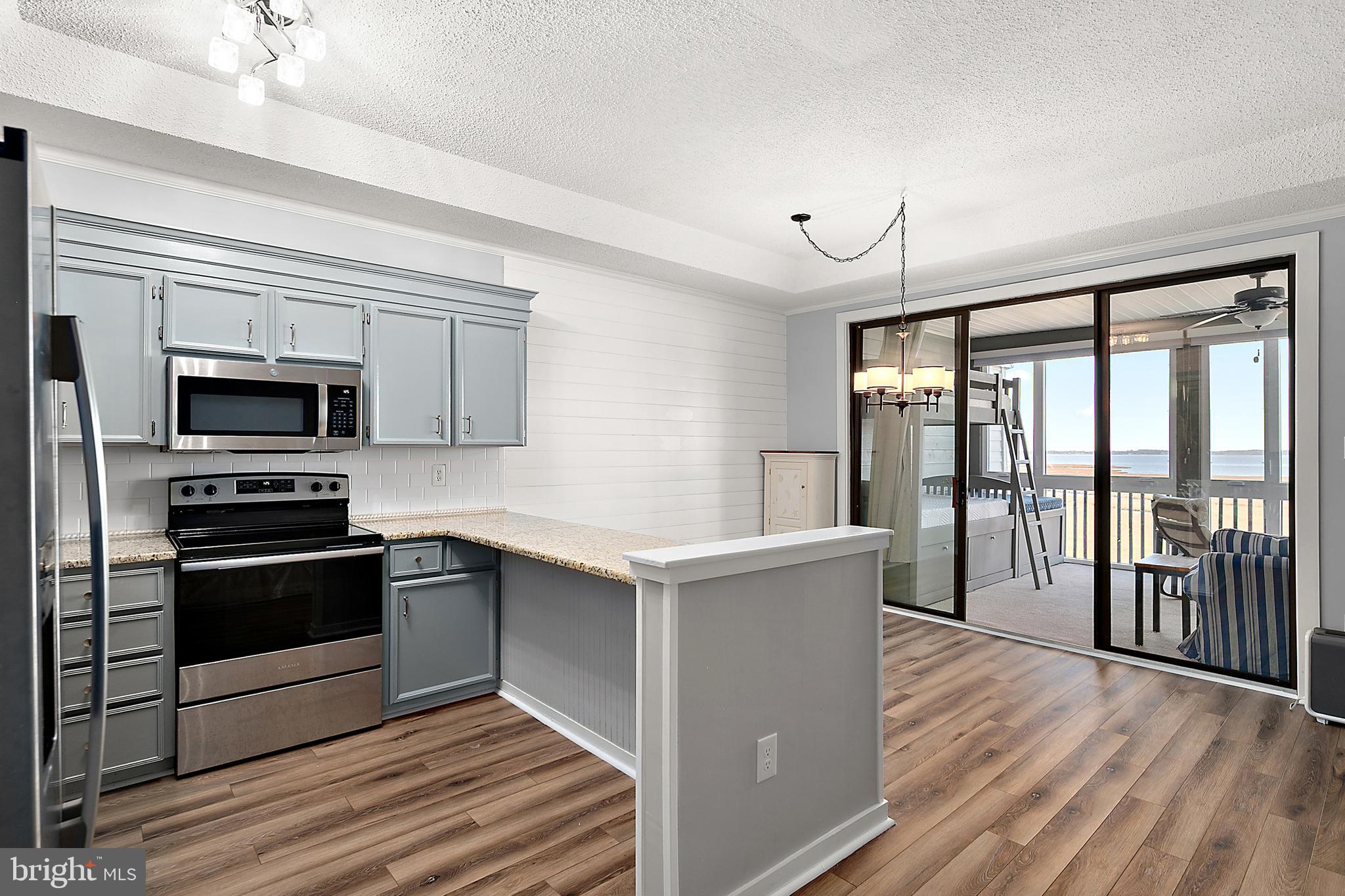 119 Old Landing Road, Unit 302B Ocean City, MD 21842 - Photo 25 of 46 a kitchen with stainless steel appliances granite countertop a stove and a refrigerator