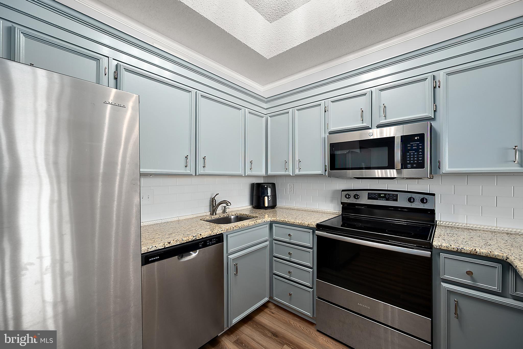 119 Old Landing Road, Unit 302B Ocean City, MD 21842 - Photo 27 of 46 a kitchen with stainless steel appliances a refrigerator stove and microwave