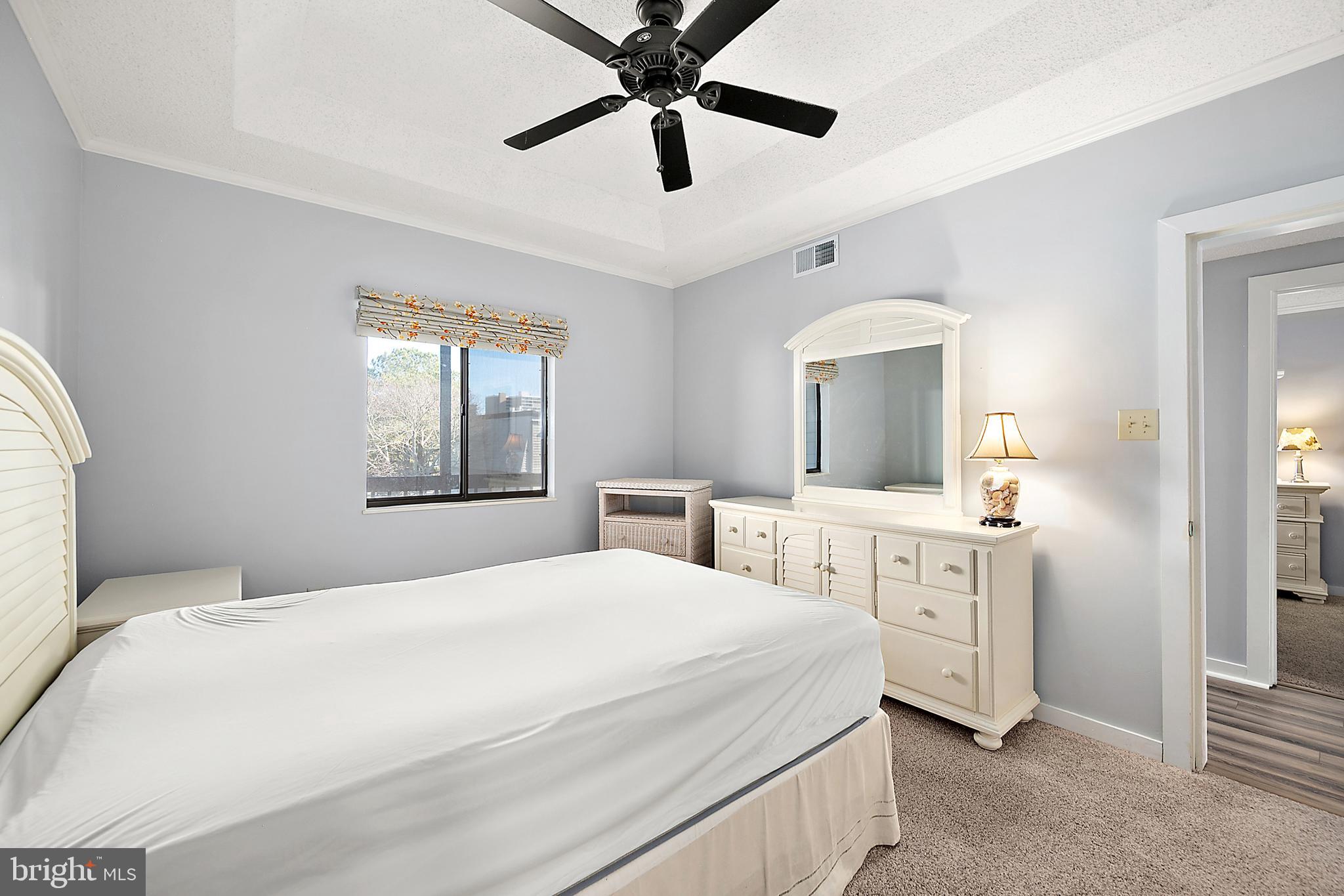 119 Old Landing Road, Unit 302B Ocean City, MD 21842 - Photo 31 of 46 a bedroom with a large bed and a chandelier