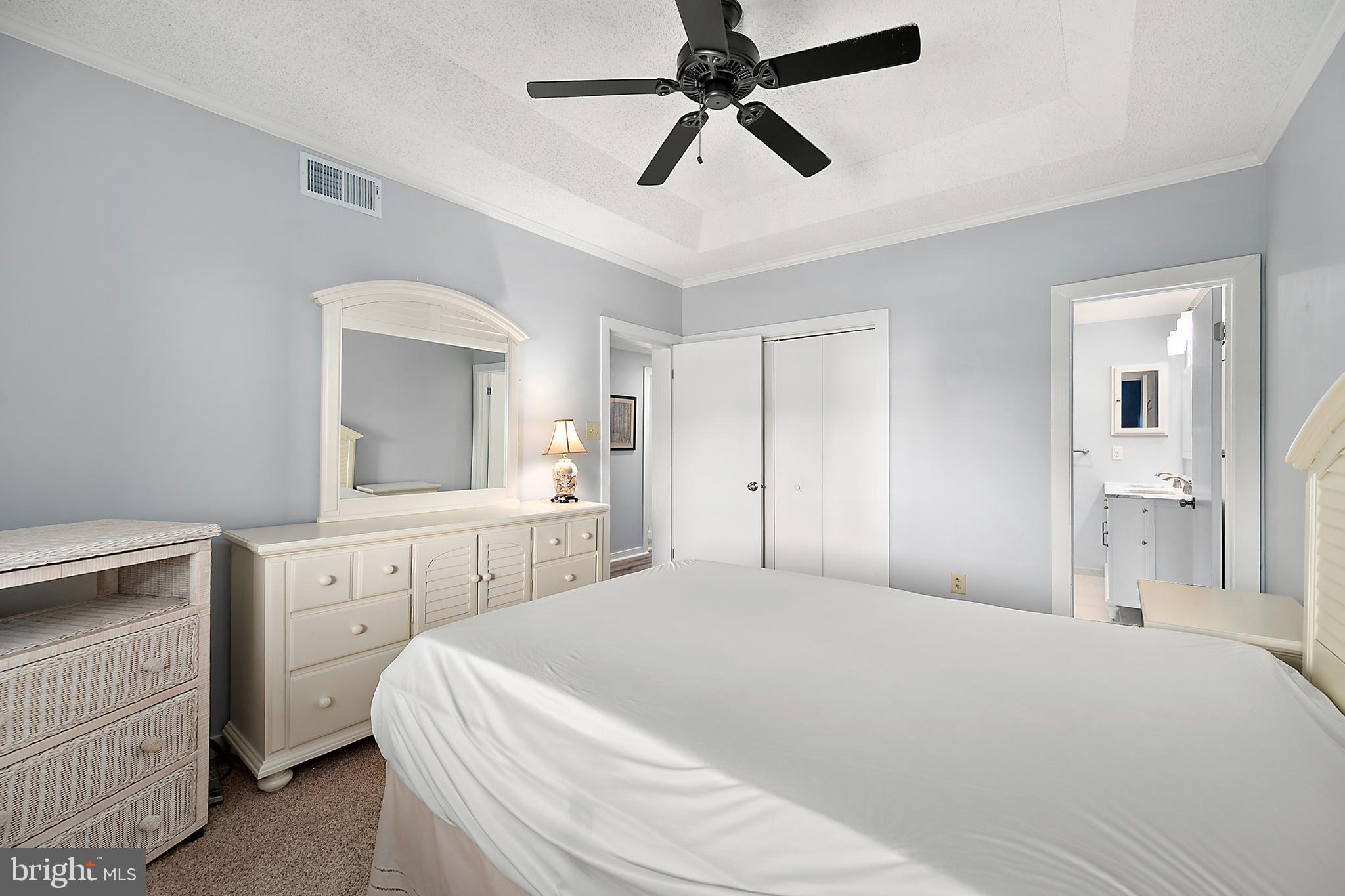 119 Old Landing Road, Unit 302B Ocean City, MD 21842 - Photo 32 of 46 a bedroom with a bed and a chandelier