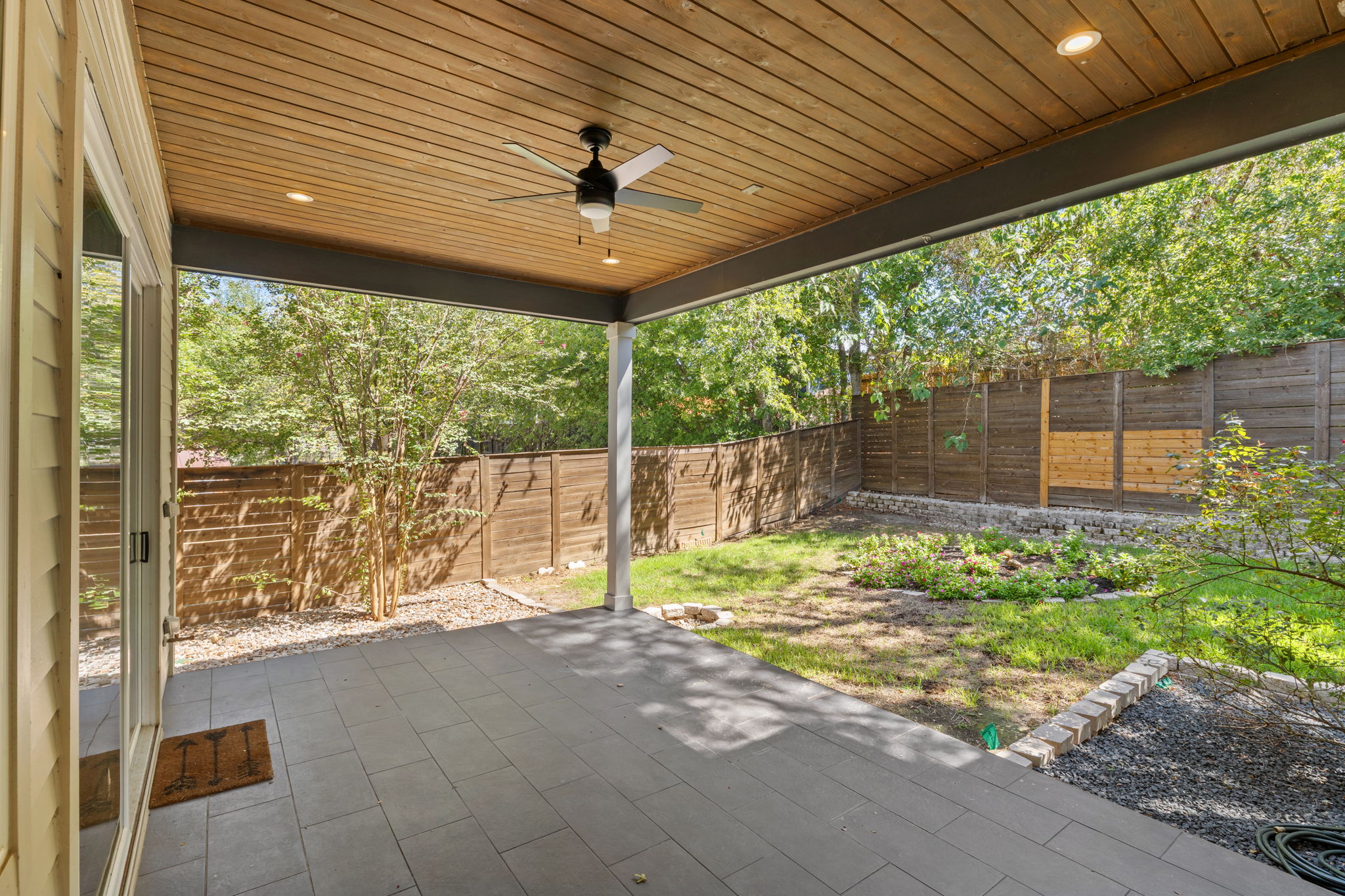 1719 Bunche Road Austin, TX 78721 - Photo 5 of 36 Tiled flooring and a warm wood ceiling anchor this sheltered outdoor living space.