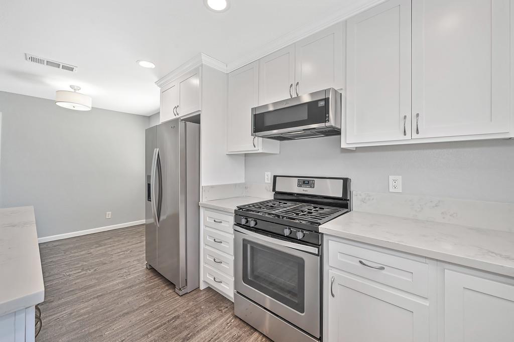 8037 Ruthwood Way Orangevale, CA 95662 - Photo 14 of 37 a kitchen with stainless steel appliances white cabinets and a stove