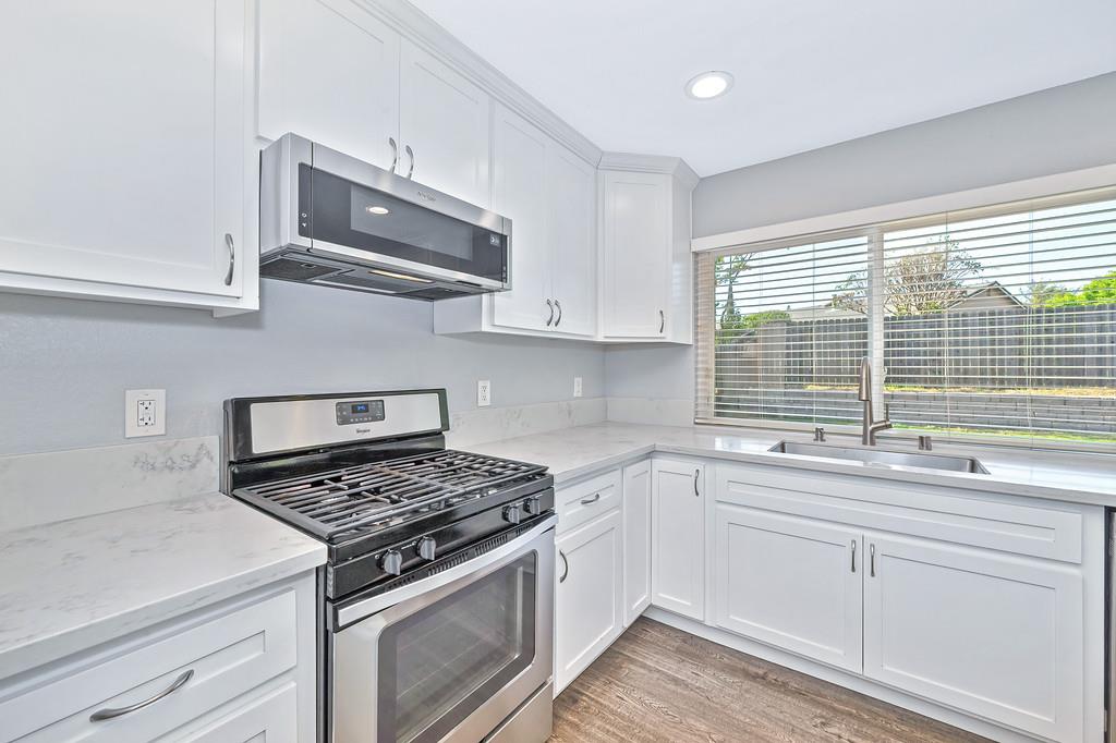 8037 Ruthwood Way Orangevale, CA 95662 - Photo 17 of 37 a kitchen with stainless steel appliances white cabinets and a stove top oven