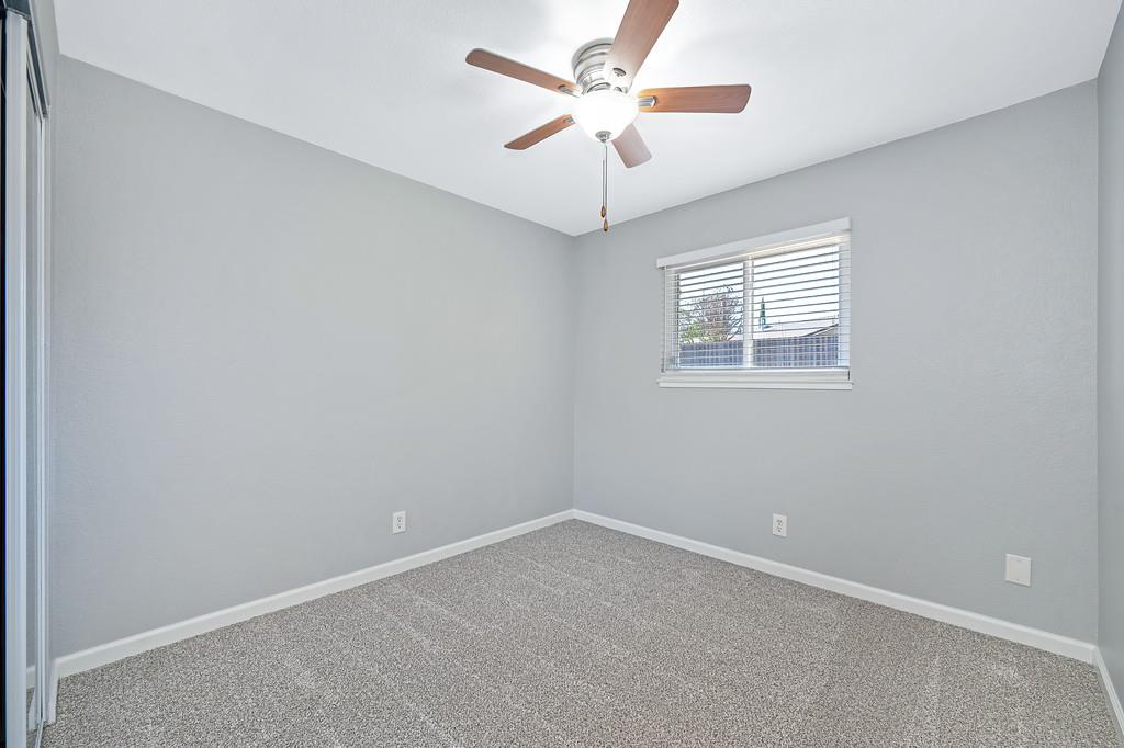 8037 Ruthwood Way Orangevale, CA 95662 - Photo 26 of 37 an empty room with a chandelier fan and windows
