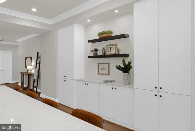 a view of a hallway with workspace and living room