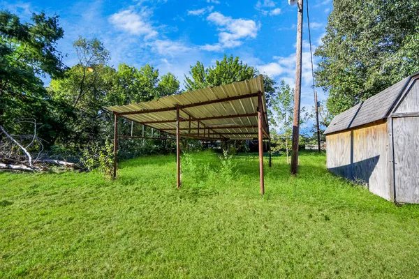 a view of house with a backyard