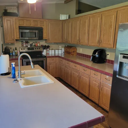 a kitchen with stainless steel appliances a stove a sink a microwave and cabinets