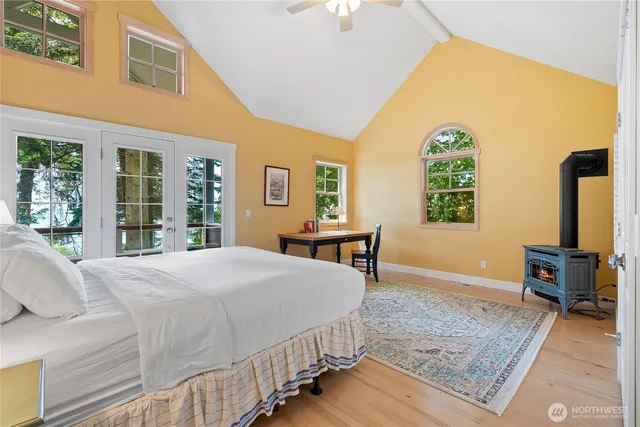 a bedroom with a bed a table and windows