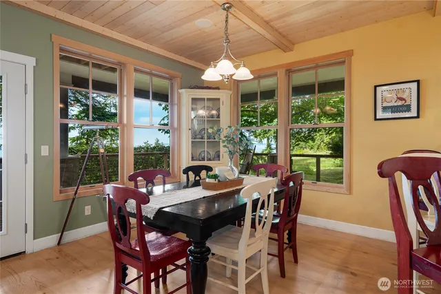 a view of a dining room with furniture large windows and wooden floor