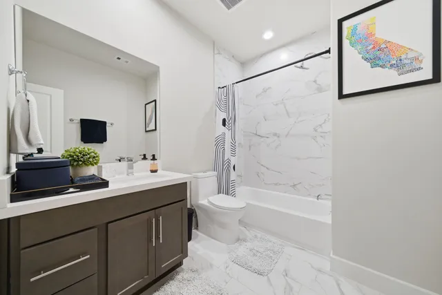 a bathroom with a double vanity sink toilet and shower