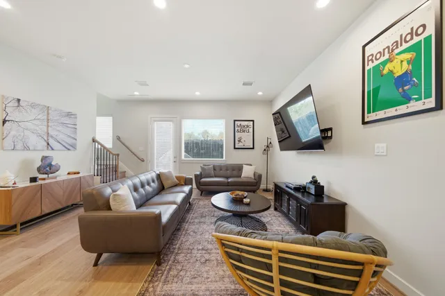 a living room with furniture a flat screen tv and a window