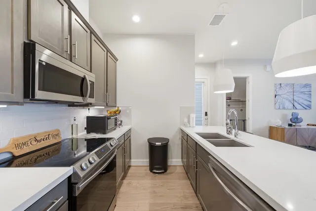 a kitchen with stainless steel appliances a sink stove and microwave