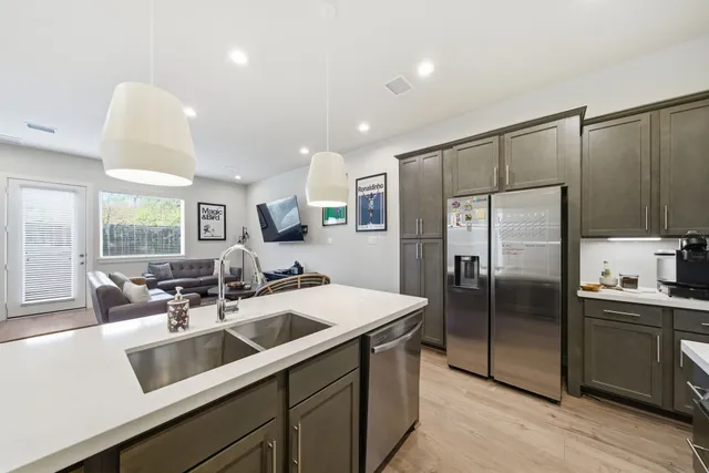 a kitchen with a sink stainless steel appliances a counter space and a window