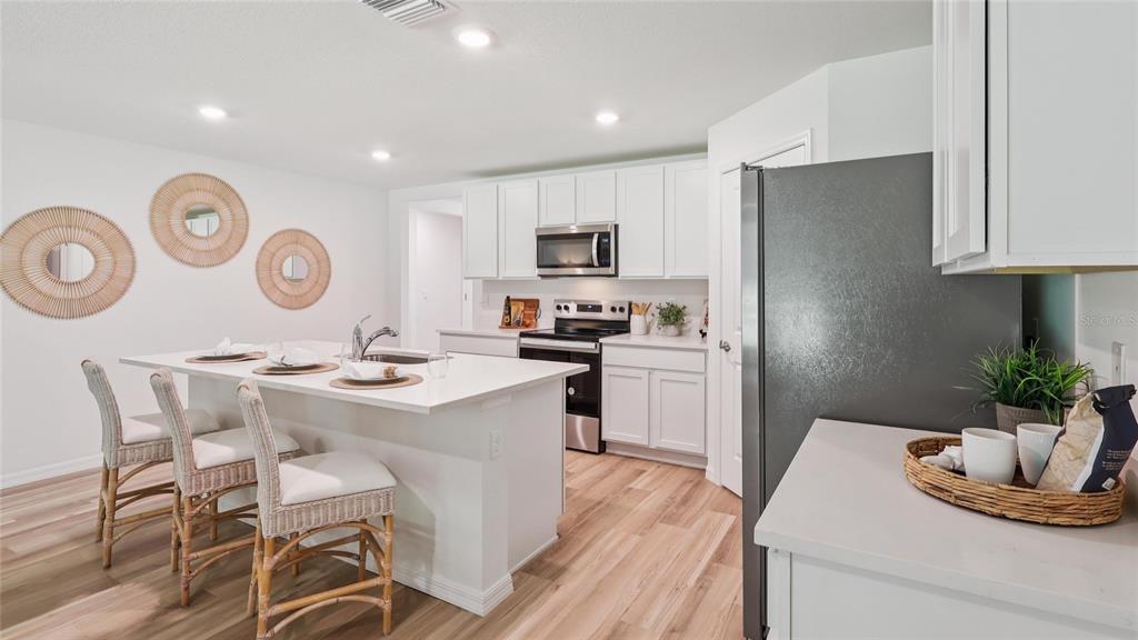 8982 Southwest 46 Terrace Ocala, FL 34476 - Photo 5 of 22 a kitchen with a refrigerator and a stove top oven
