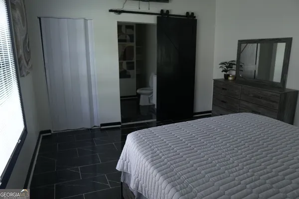 a bedroom with a bed and a mirror