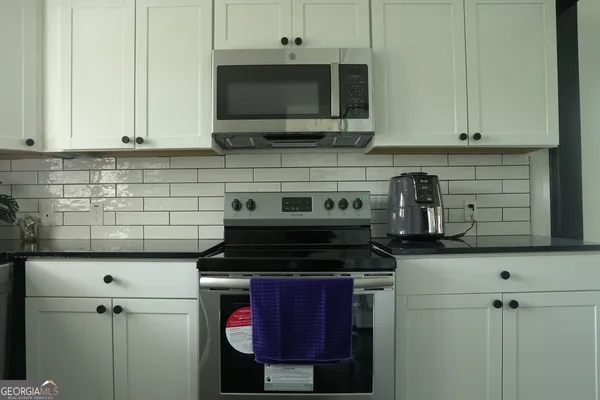 a kitchen with stainless steel appliances granite countertop a stove and a microwave