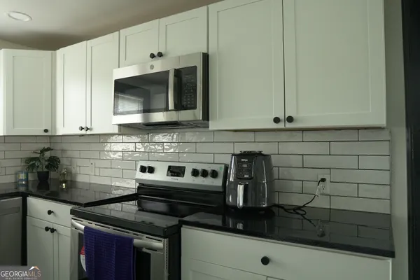 a kitchen with stainless steel appliances a stove and a microwave