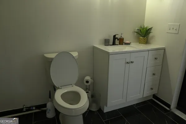a bathroom with a toilet a sink and mirror