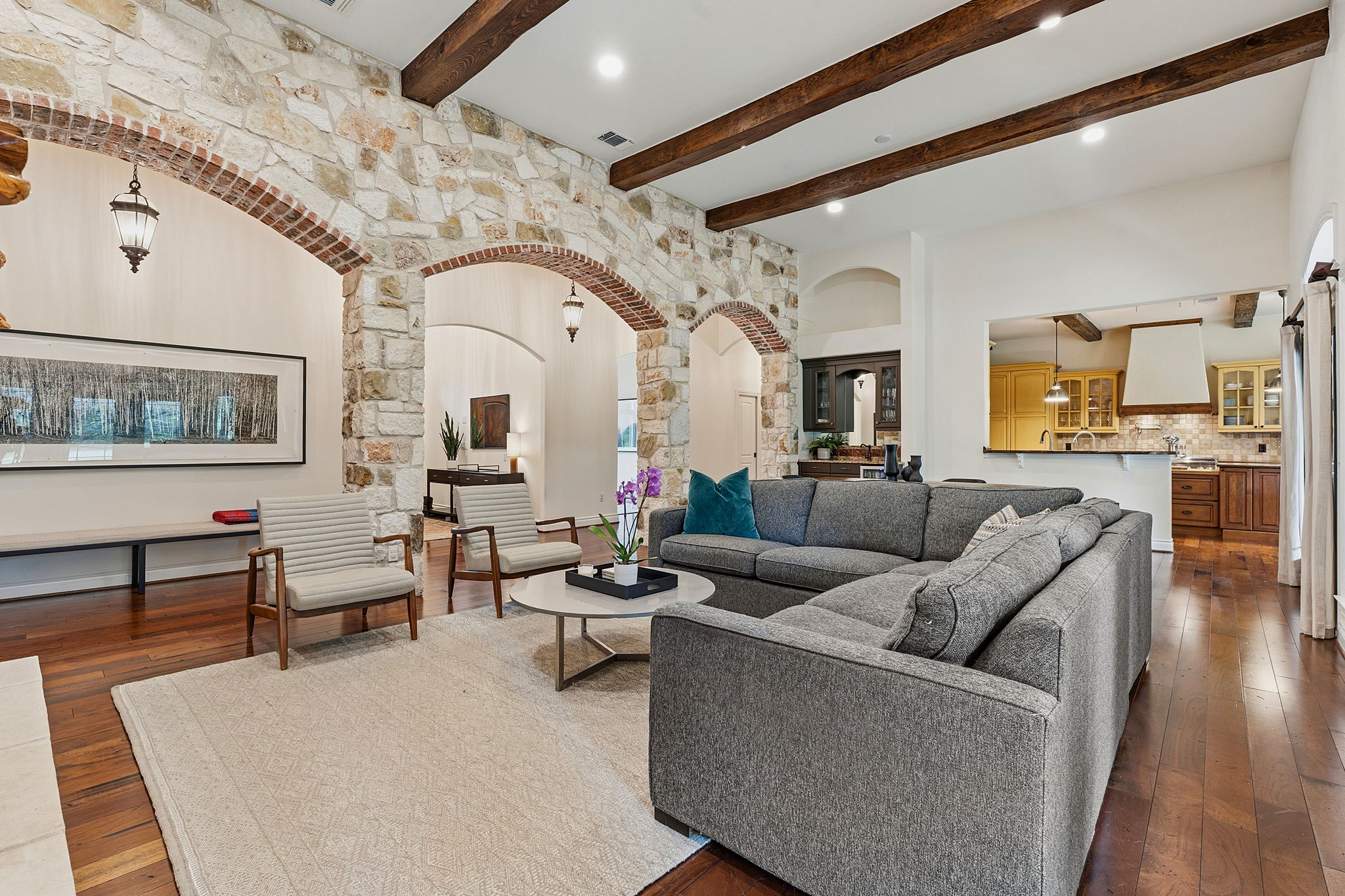 8121 Bluff Trail Austin, TX 78737 - Photo 15 of 40 Exposed wood beams and stone arches create a captivating visual in this generous gathering space.