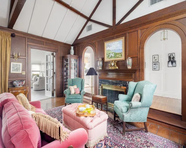 a living room with furniture fireplace and a large window