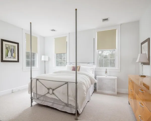 a bed sitting in a bedroom next to a window