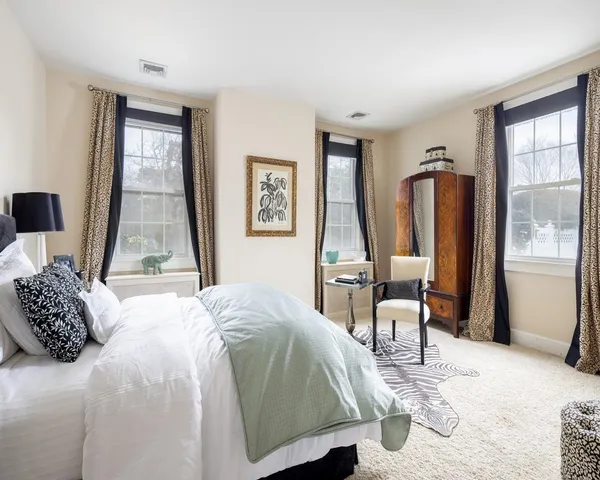 a bedroom with a bed and large windows