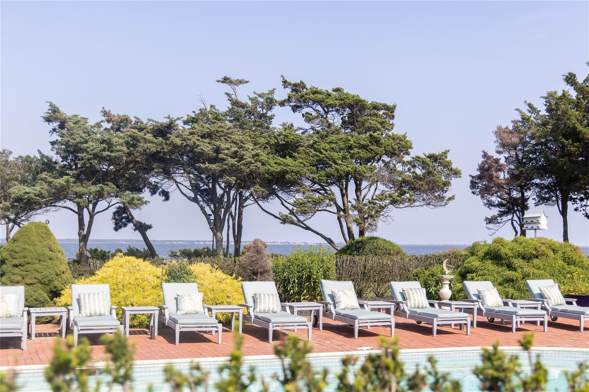 16 Point Road Bellport, NY 11713 - Photo 8 of 34 a view of swimming pool with outdoor seating and trees