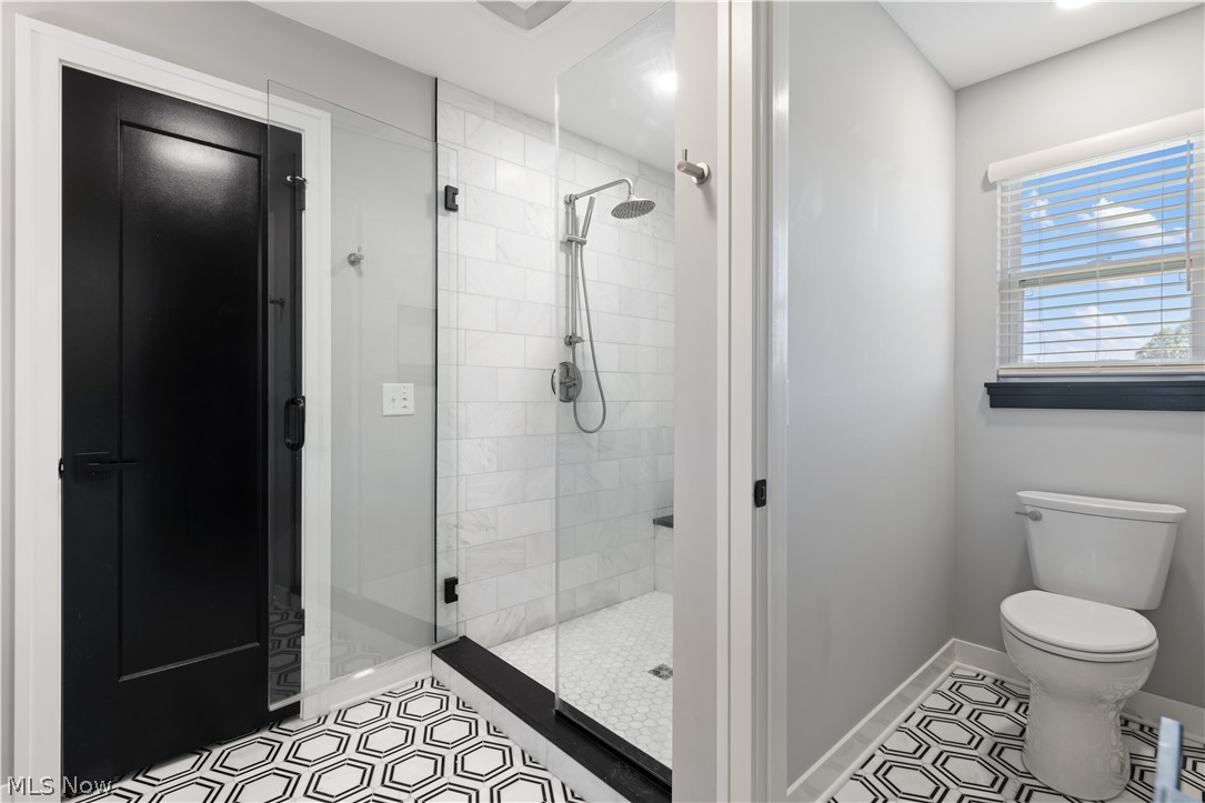 35799 Lorain Road North Ridgeville, OH 44039 - Photo 33 of 50 Owner's Bathroom featuring tile patterned flooring, toilet, and tiled shower