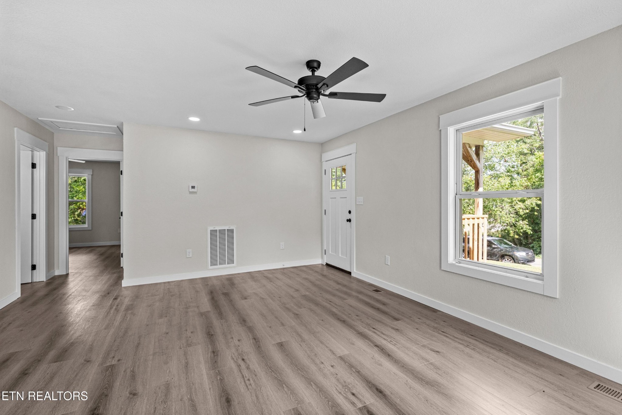 126 Double Cave Road Rutledge, TN 37861 - Photo 5 of 20 an empty room with wooden floor chandelier fan and windows
