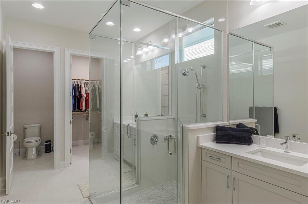 8982 Gustavia Court Naples, FL 34113 - Photo 14 of 44 a bathroom with a double sink shower and a mirror