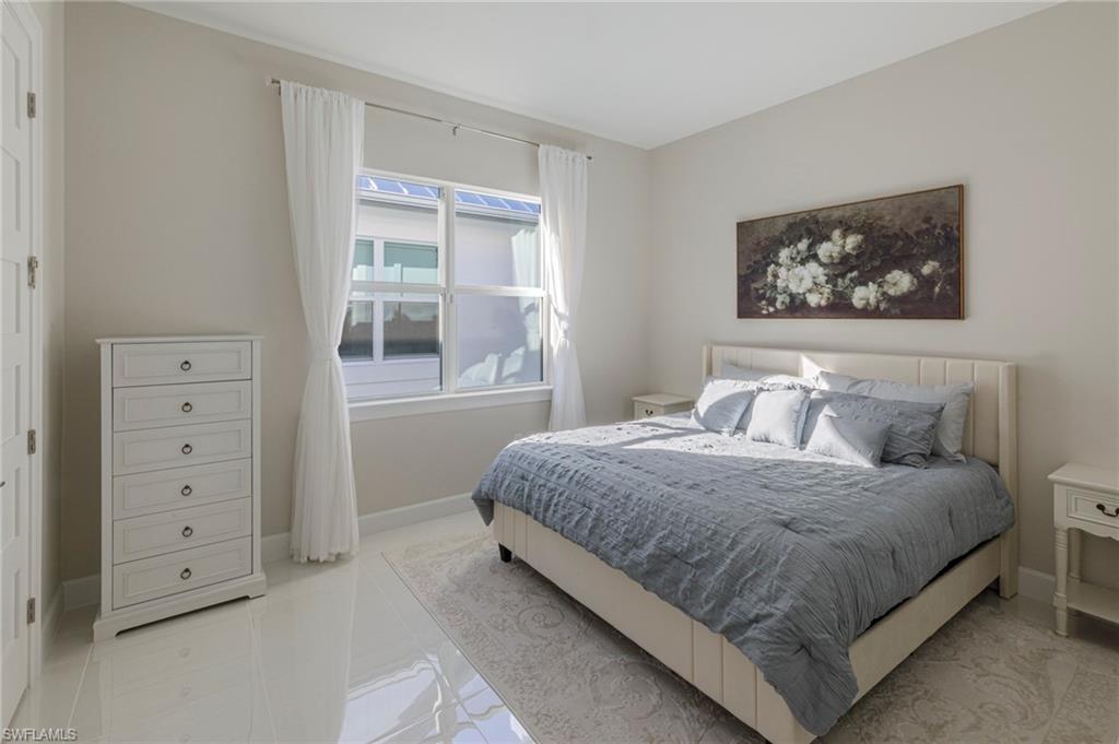 8982 Gustavia Court Naples, FL 34113 - Photo 19 of 44 a bedroom with a bed and a window