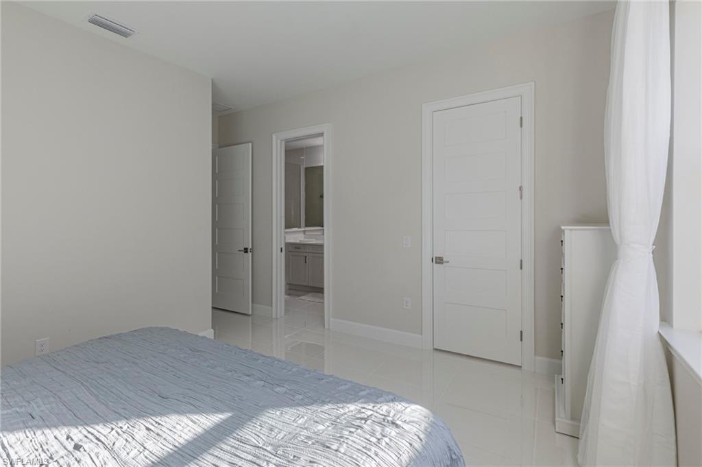 8982 Gustavia Court Naples, FL 34113 - Photo 20 of 44 a bedroom with a bed and hallway