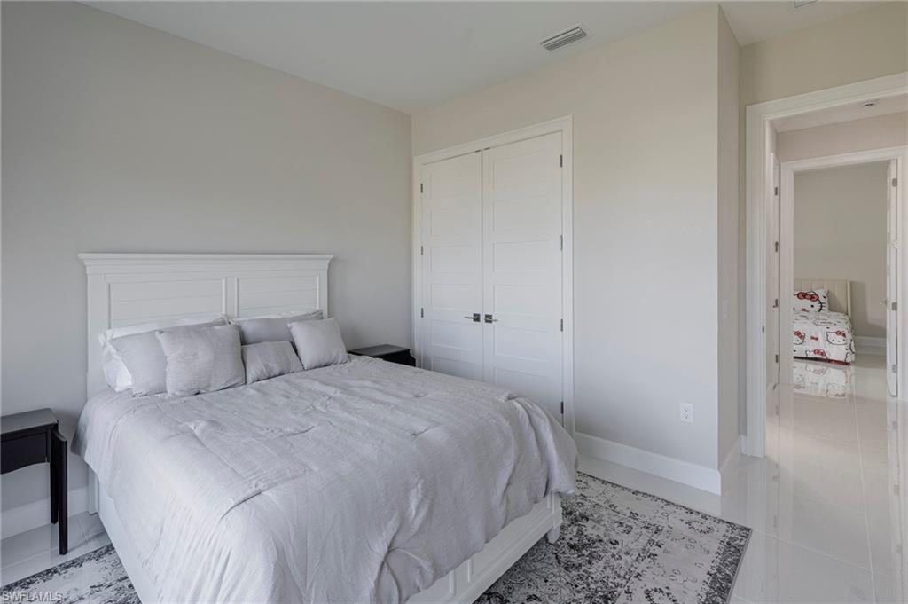 8982 Gustavia Court Naples, FL 34113 - Photo 23 of 44 a bedroom with a bed and a rug