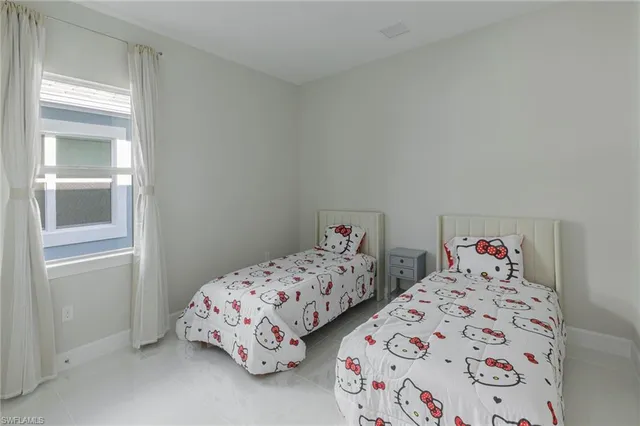 a bedroom with two beds and a window