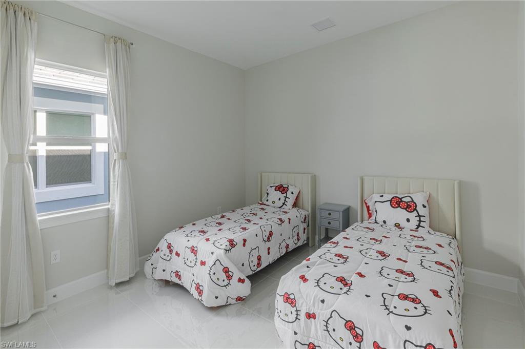 8982 Gustavia Court Naples, FL 34113 - Photo 25 of 44 a bedroom with two beds and a window
