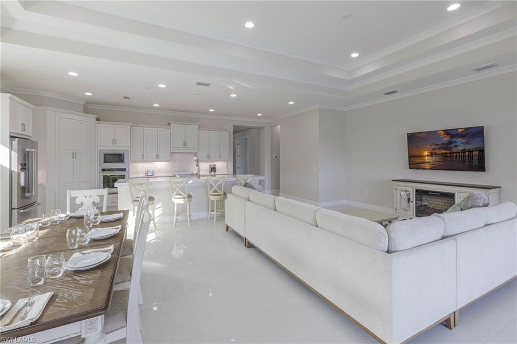 8982 Gustavia Court Naples, FL 34113 - Photo 9 of 44 a living room with furniture and a flat screen tv