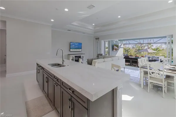 a kitchen with stainless steel appliances a stove a sink a microwave and a dining table