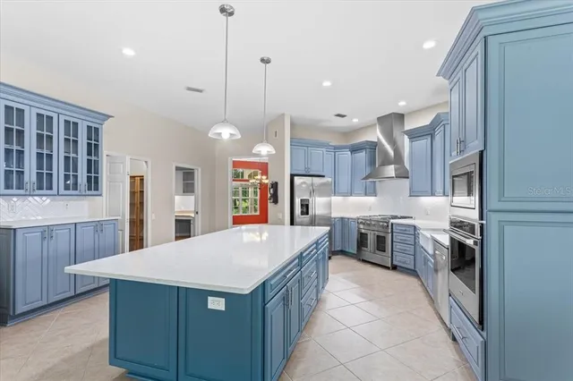 a kitchen with a stove a sink a center island and a window