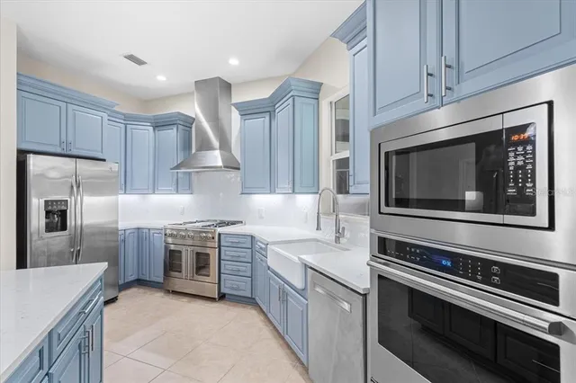 a kitchen with stainless steel appliances granite countertop a sink and a wooden floors